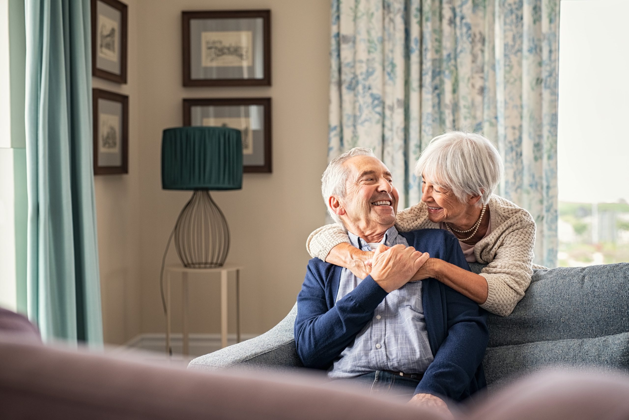 senior couple hugging and smiling on the sofa